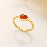 14k gold filled ring with a red Carnelian gemstone on a light beige background